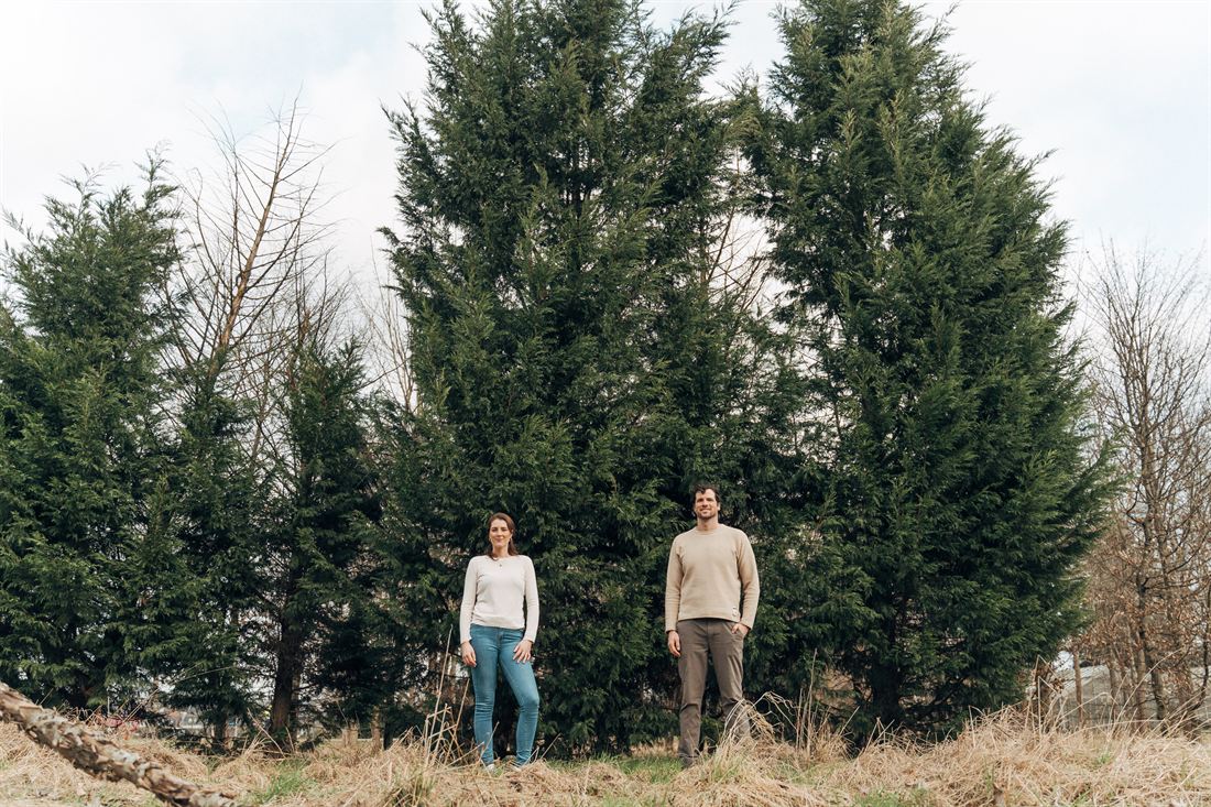 Paar bei einem Spaziergang vor hohen Nadelbäumen – Familienfotograf Duisburg